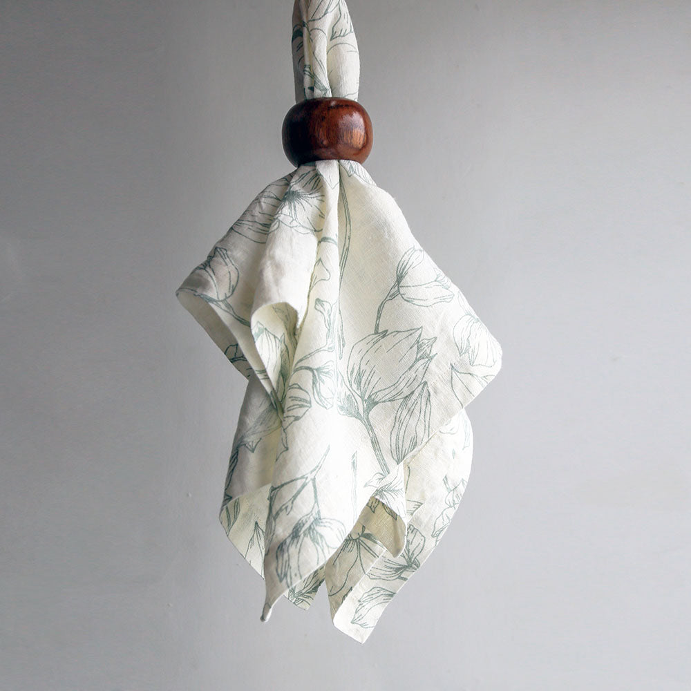 Blue and white linen napkin with napkin ring on white background