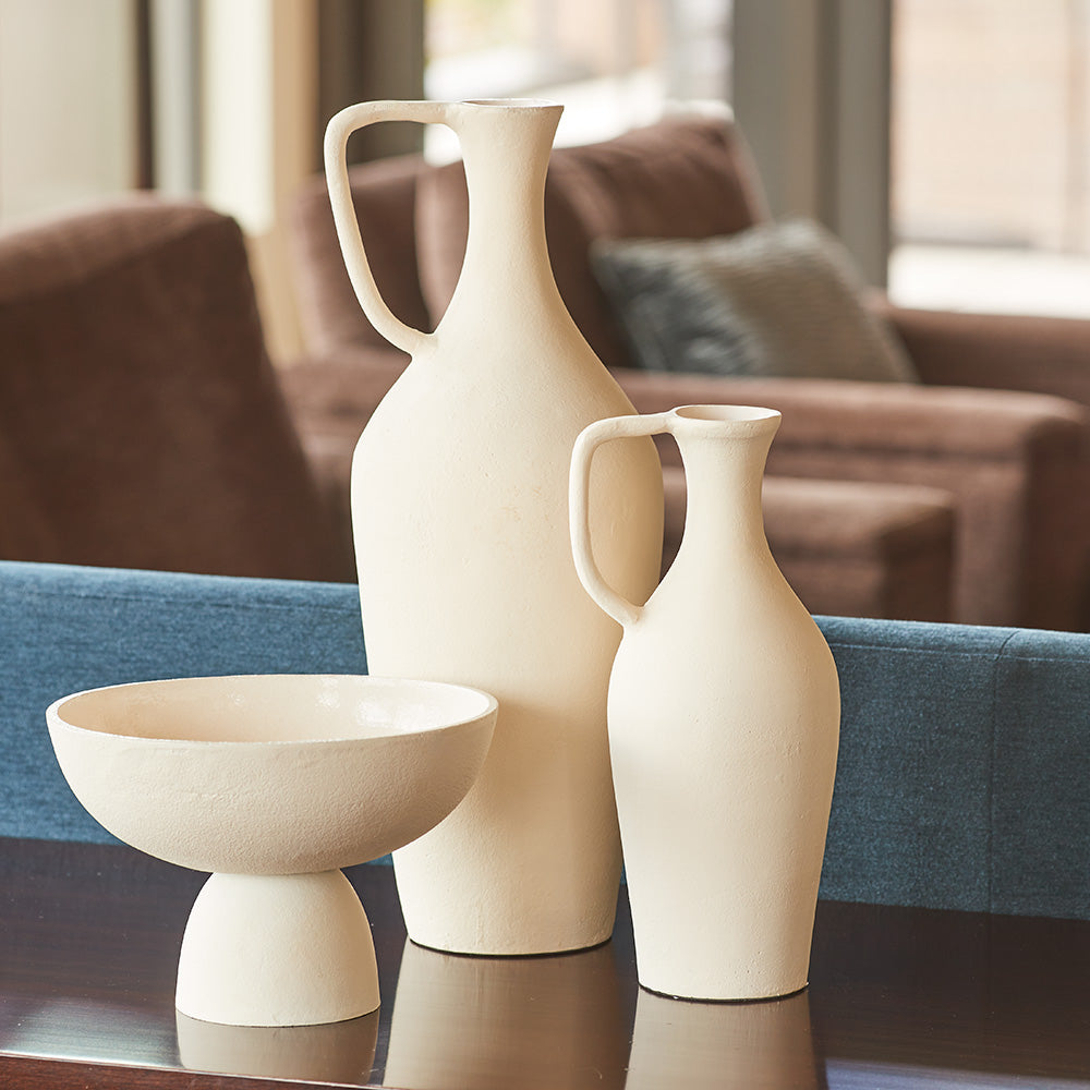 Close up of matching creme pitchers on side table